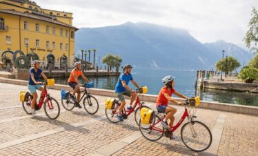 Group of people riding bikes by lake garda